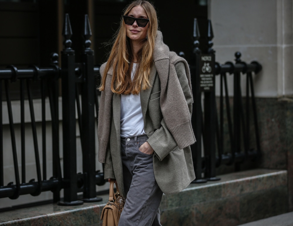 Medium shot of a woman in a relaxed-fit blazer focusing on the drape and shoulder fit in a monochrome tone.