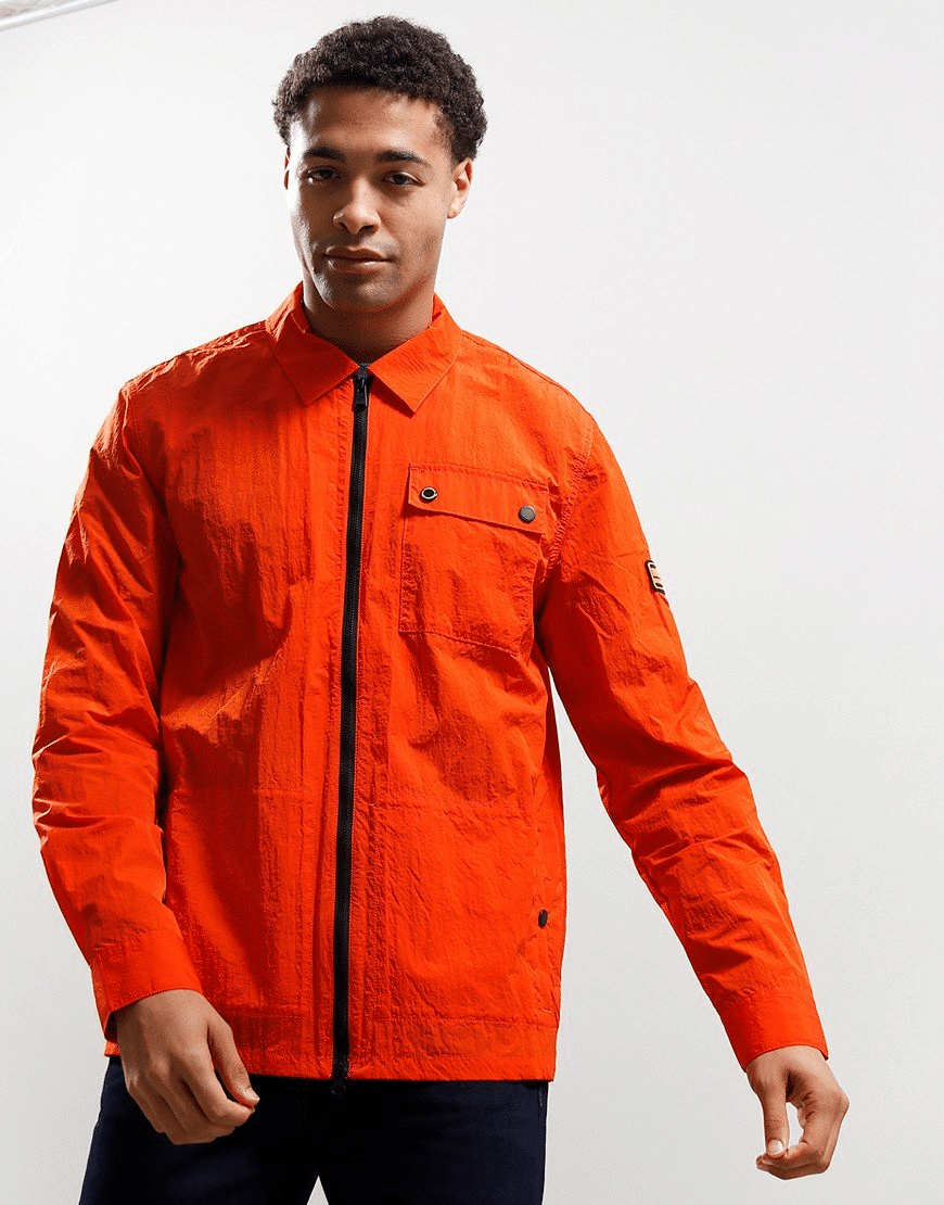 Man modeling a vibrant orange textured technical jacket with a black chest pocket.