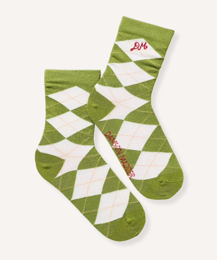 Close-up of argyle socks featuring chartreuse and navy patterns paired with neutral sneakers.