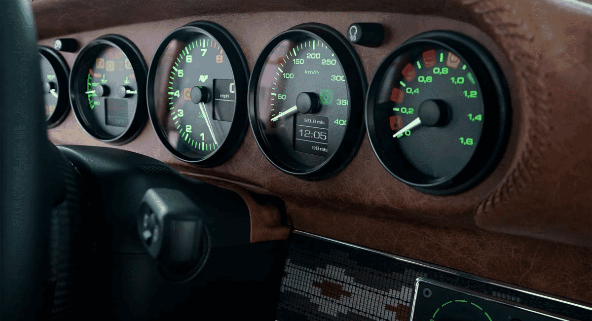 Luxury car dashboard featuring analog gauges with green backlighting and brown leather trim.