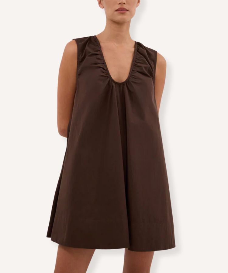 A model wearing a chocolate brown mini dress with a clean, modern silhouette.