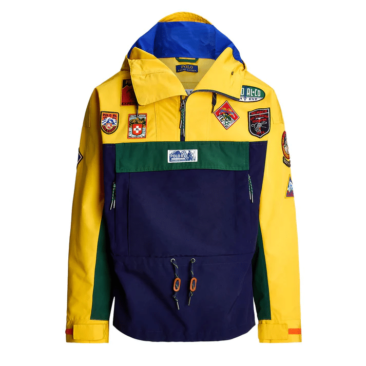 Vibrant yellow and navy color-blocked outdoor jacket with a half-zip front and multiple brand patches.