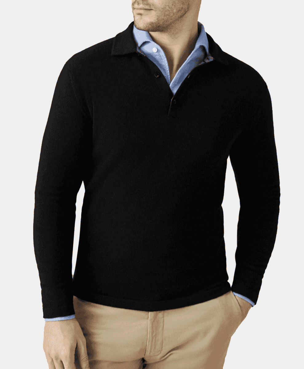 Man modeling a black long-sleeve polo sweater layered over a light blue collared shirt.