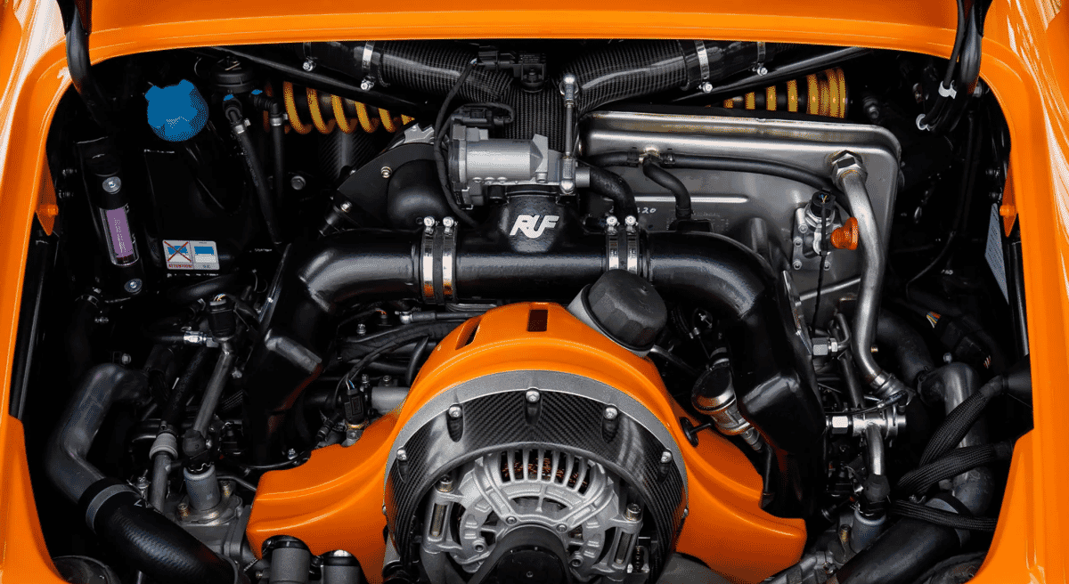 Close-up of the RUF engine bay with orange components and carbon fiber accents.