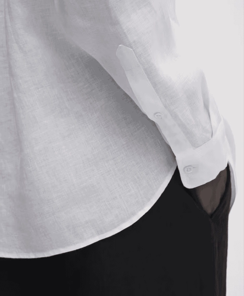 Close-up of a white linen button-up shirt showing the detailed fabric texture and weave.