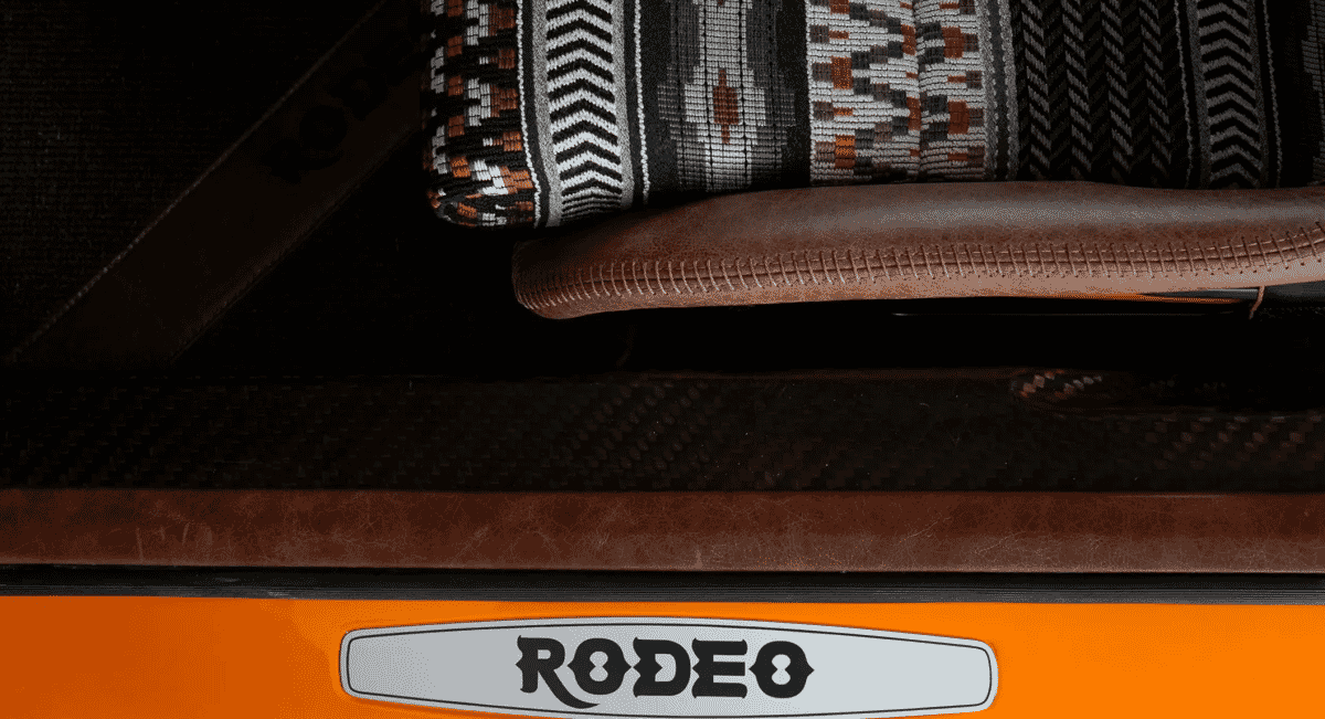 Close-up of a car door panel featuring patterned textile and RODEO branding.