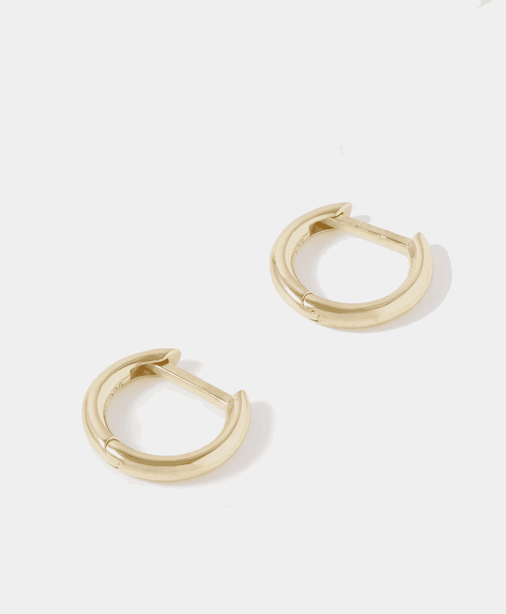 A pair of polished gold-plated hoop earrings on a clean white background.