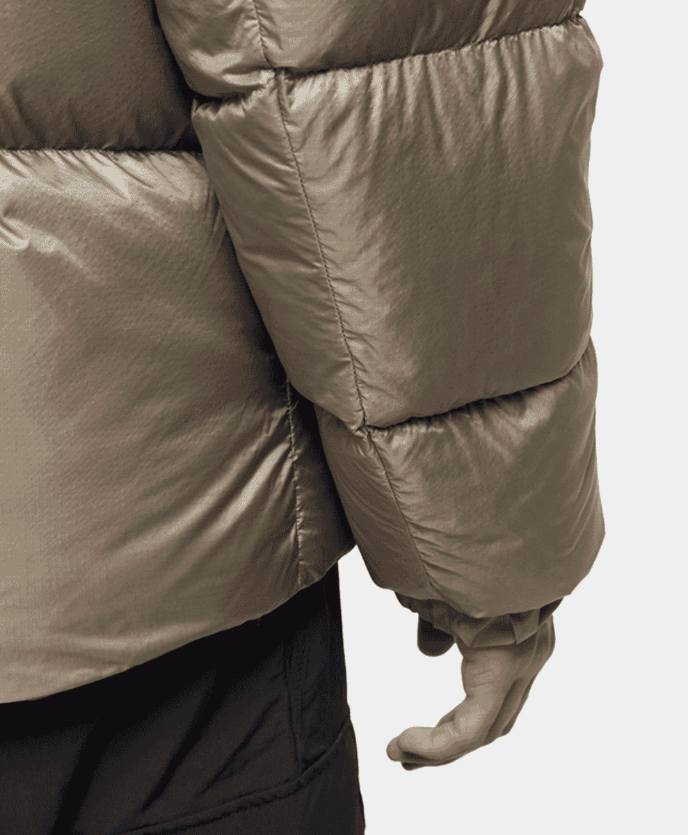 Close-up detail of the quilted metallic taupe fabric on a padded puffer jacket.