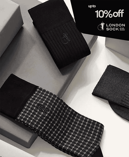 Men's dress socks in black ribbed and houndstooth patterns on white display boxes.