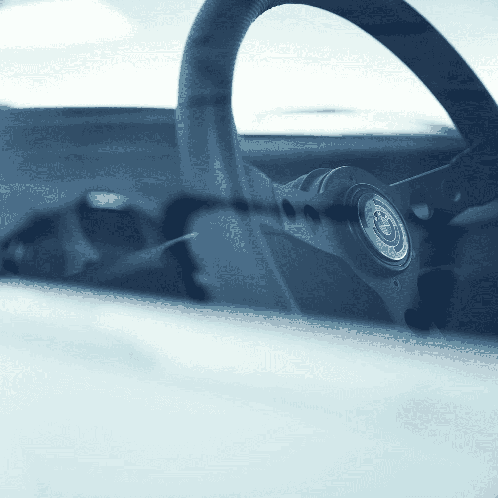 Interior view of a BMW steering wheel with a cool blue aesthetic filter.