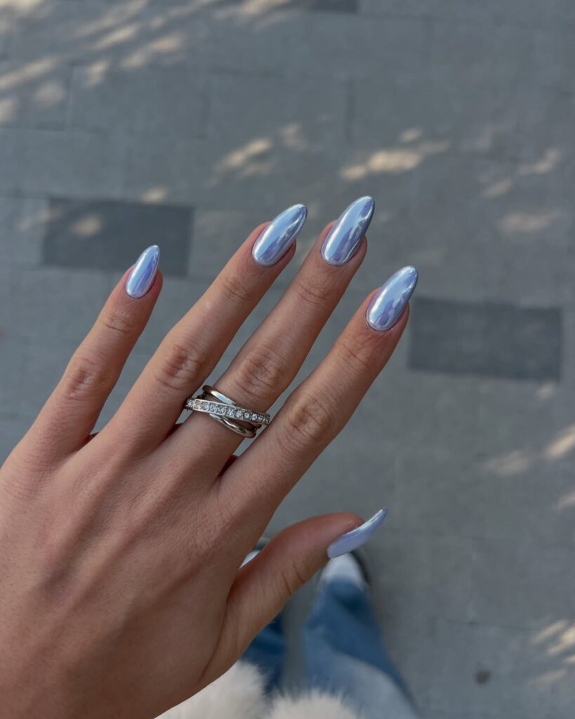 Short nails with a nude iridescent chrome finish resembling wet pool tiles.