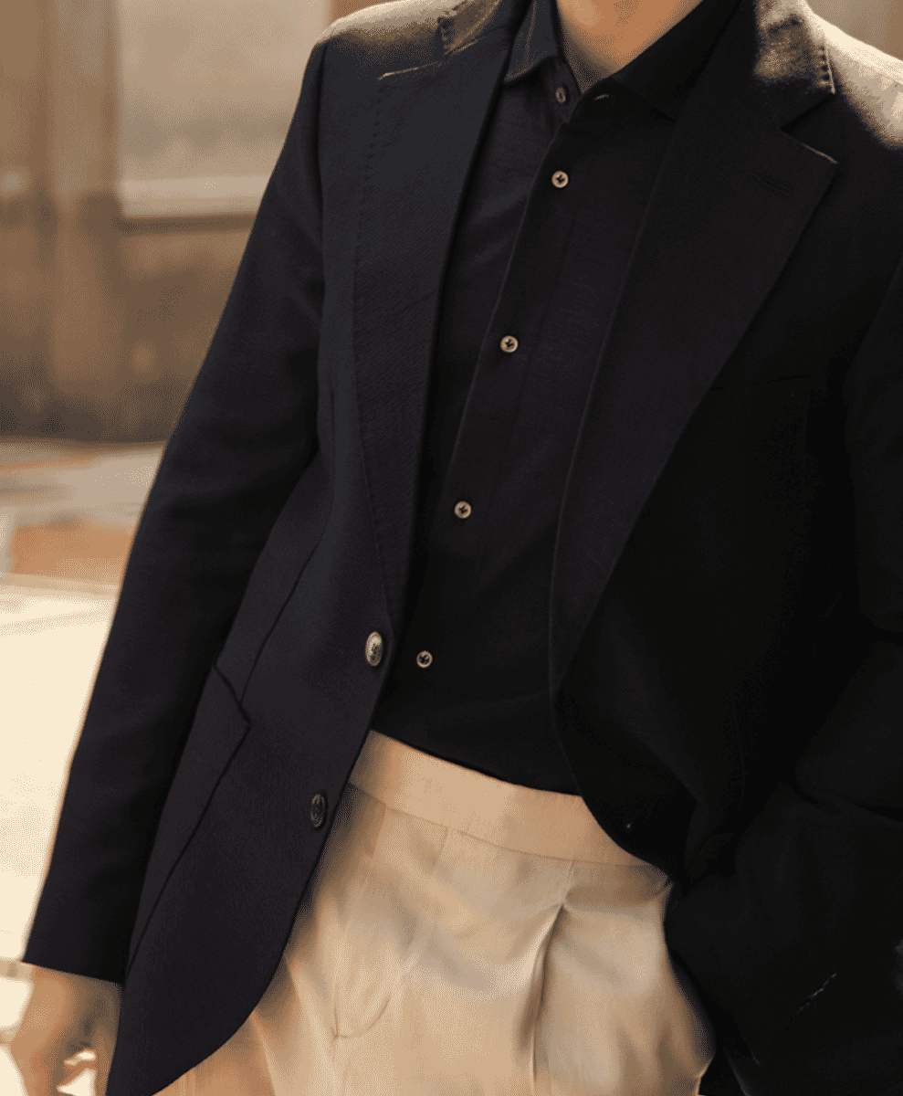 Man in a navy blazer and light beige trousers showcasing a smart-casual tailored look.