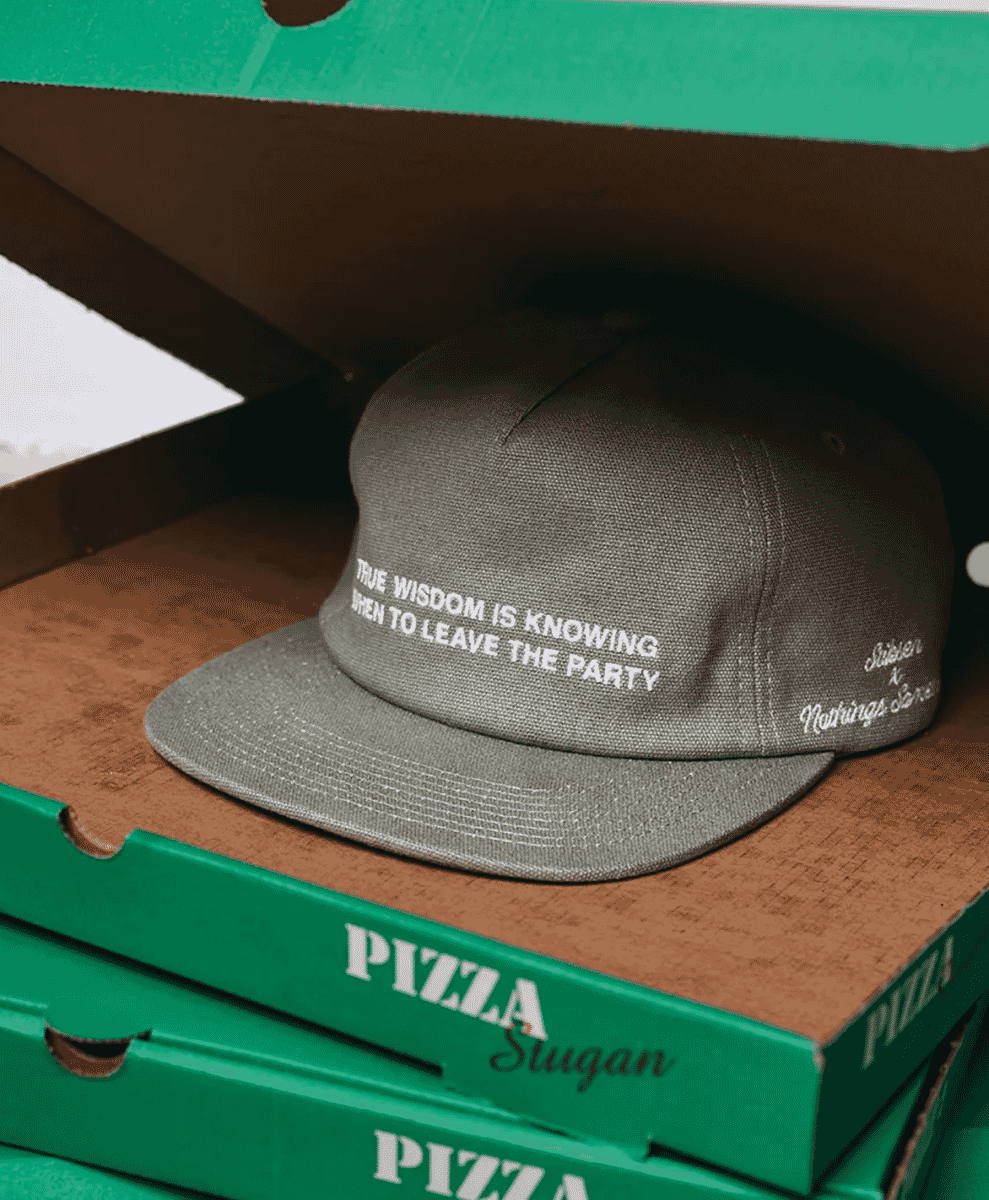Taupe Stiksen cap inside a green pizza box.