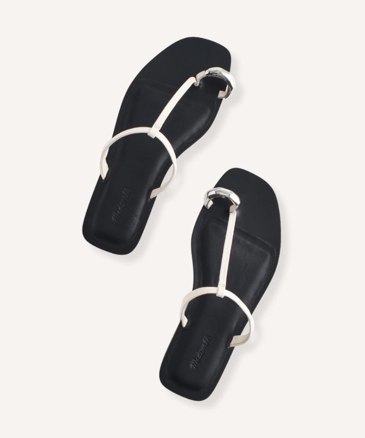 Minimalist leather sandals with a specific toe-ring loop detail.
