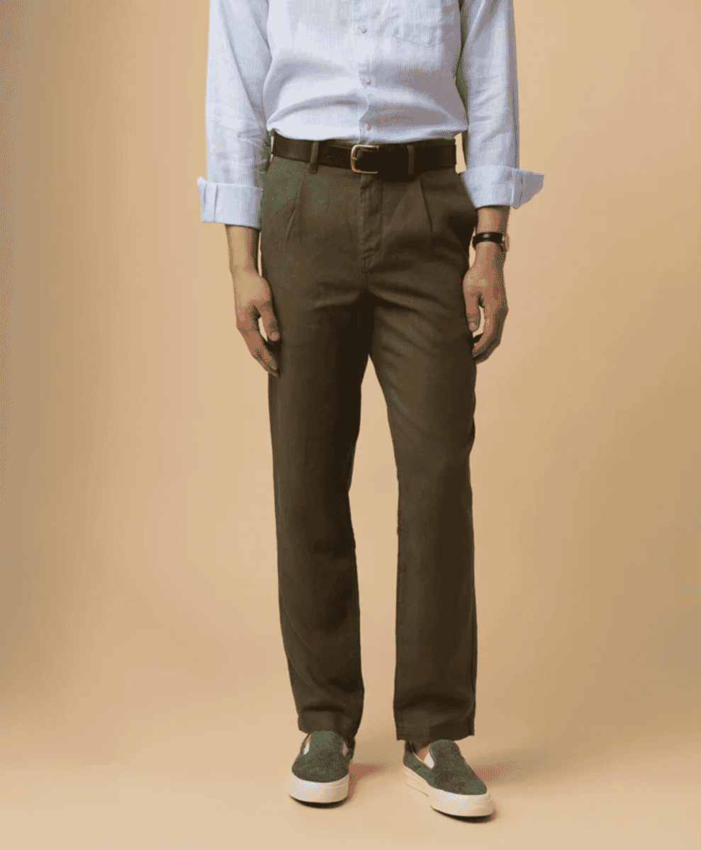 Man in olive-green pleated linen trousers and a light blue shirt.