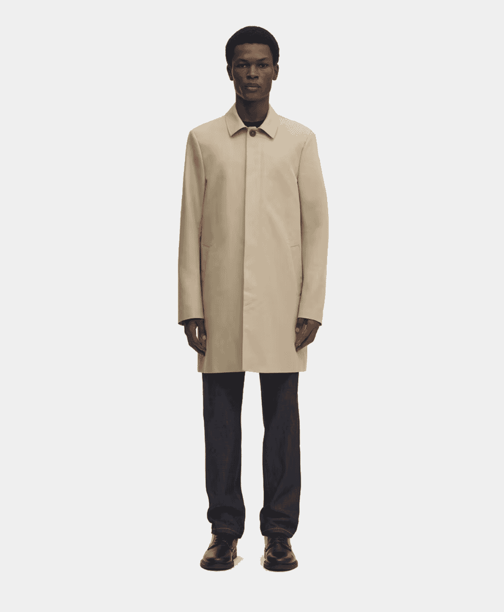 Man in a light beige knee-length trench car coat.