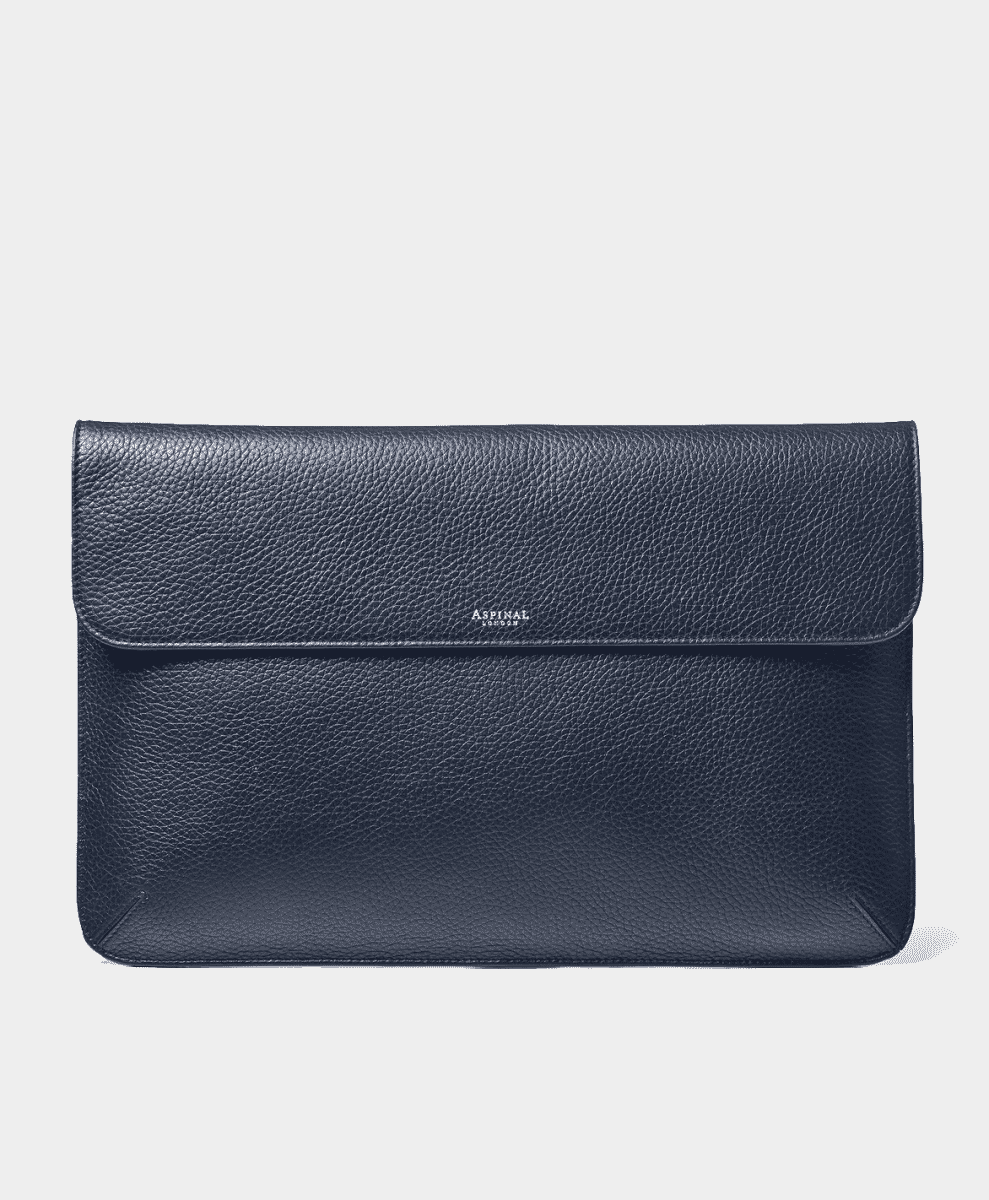 Navy blue textured leather laptop sleeve/folio with minimalist branding on a white background.