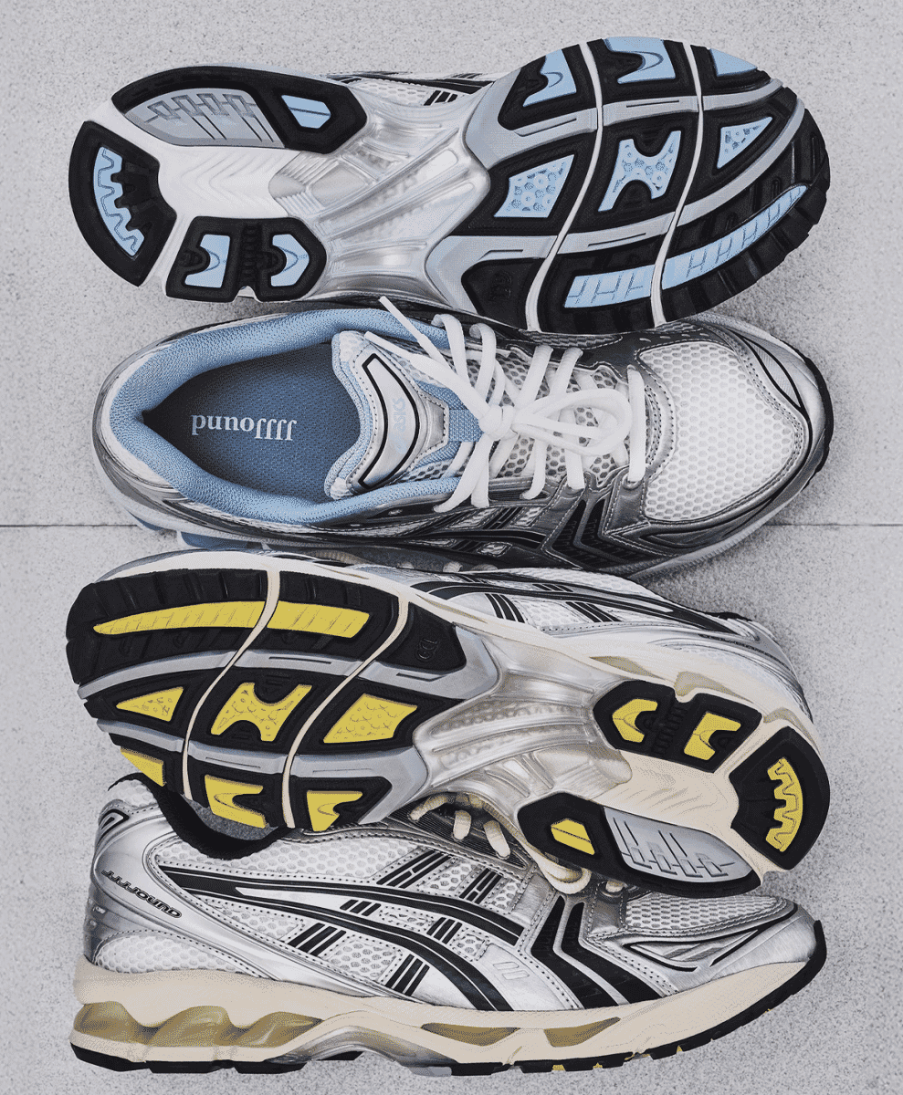 Overhead view of both JJJJound x ASICS colorways on a gray surface, showcasing the different outsole designs.