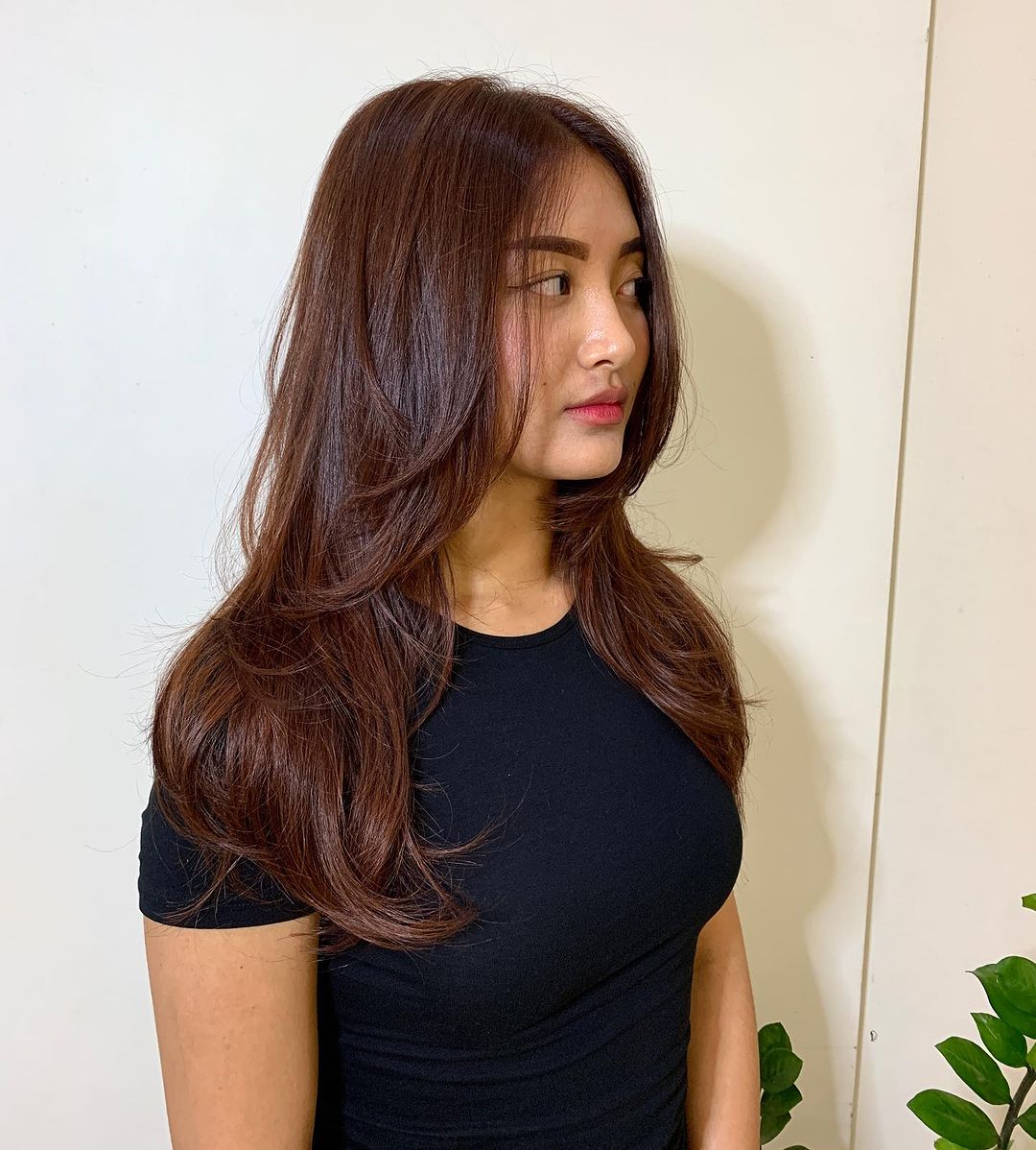 Layered haircut on medium-length hair with multifaceted chocolate copper tones.