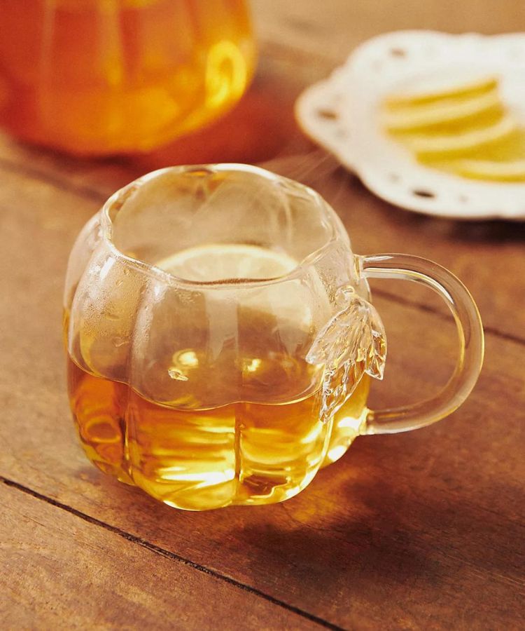 Clear glass mug shaped like a pumpkin with a sturdy handle.