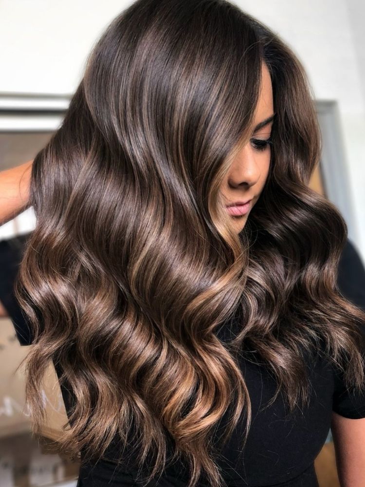 Detailed close-up of hair showing the blend of caramel and hazelnut highlights on a brown base.
