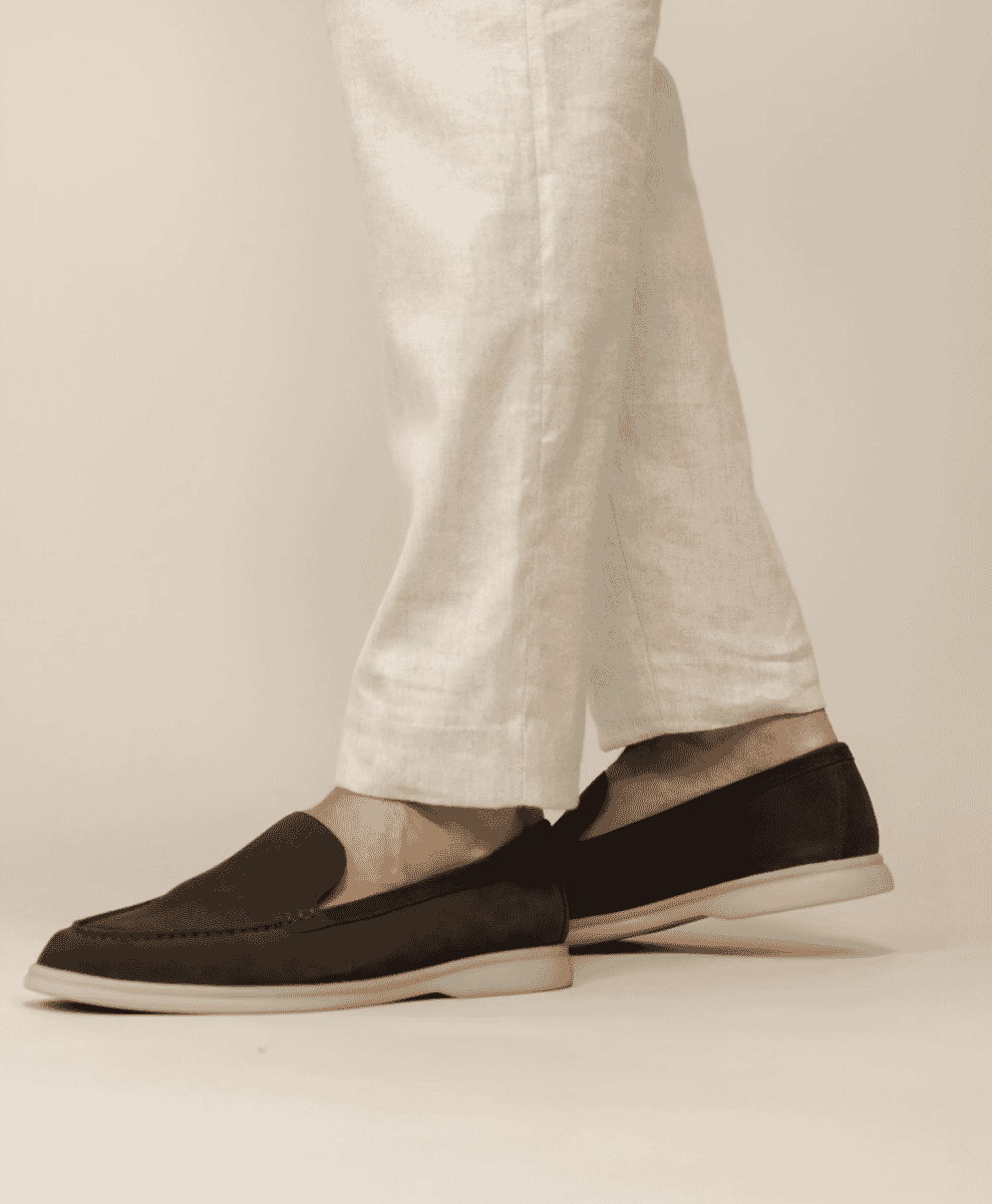 Close-up of dark brown suede loafers worn with beige linen pants