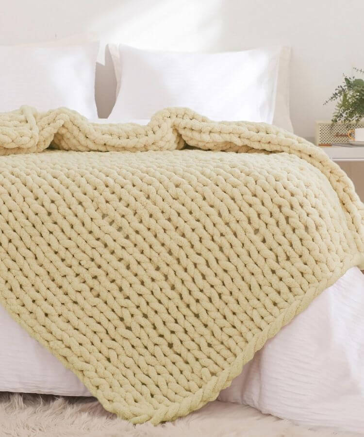 Heavy chunky knit throw blanket in a warm yellow shade.