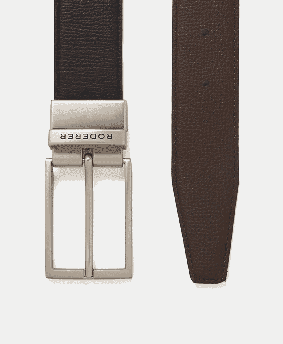 Close-up of a reversible brown leather belt with a silver-toned buckle on a white background.