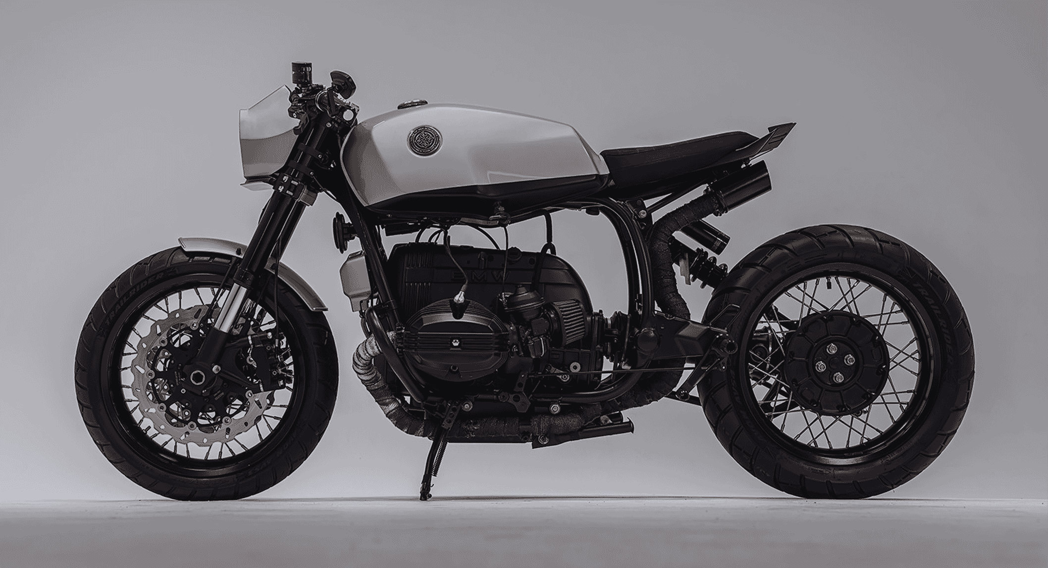 A custom BMW R100R cafe racer against a gray background showing the full profile.