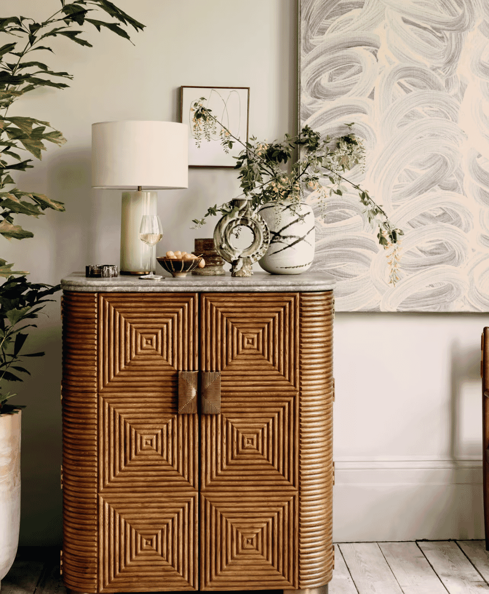 Geometric wooden cabinet with a marble top in a serene modern interior.