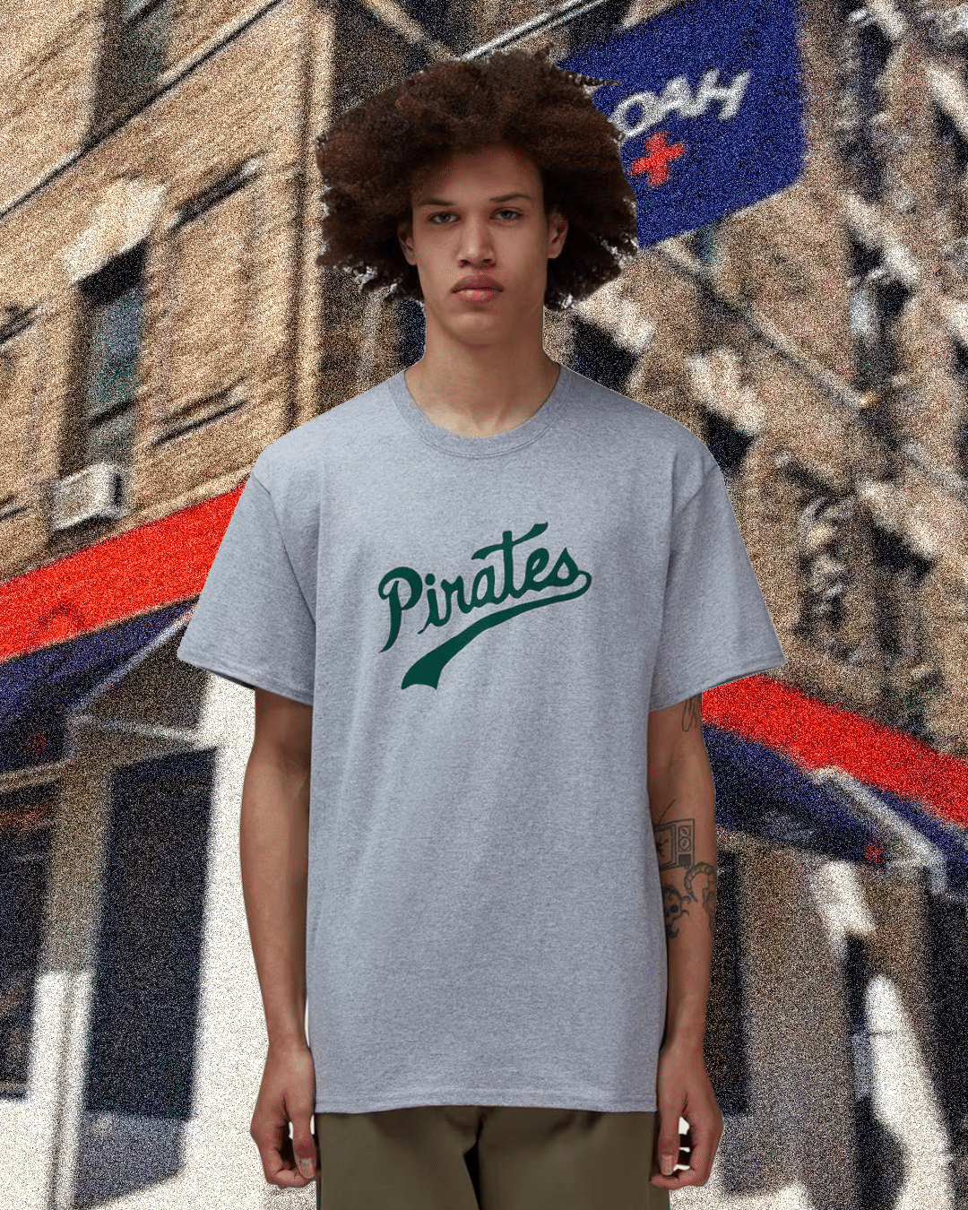 Man wearing a gray oversized t-shirt with Pirates script in green.