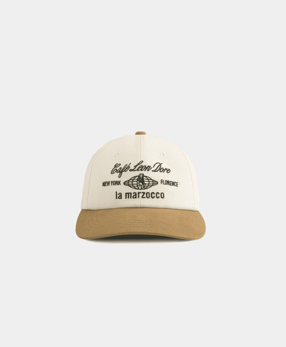 A two-tone cream and tan baseball cap featuring the Café Leon Dore globe logo.