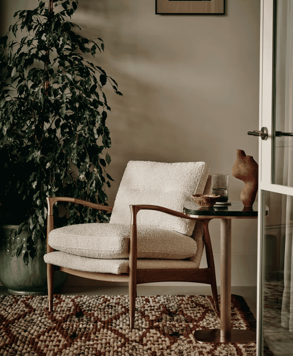 Cream bouclé armchair with a wooden frame in a Japandi-style living room.