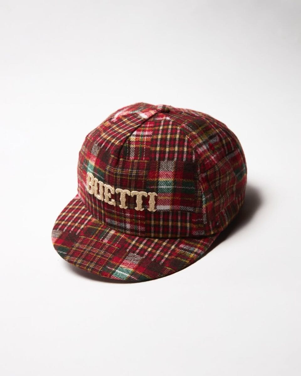 A red, green, and yellow plaid cap with BUETTI embroidery on a white background.