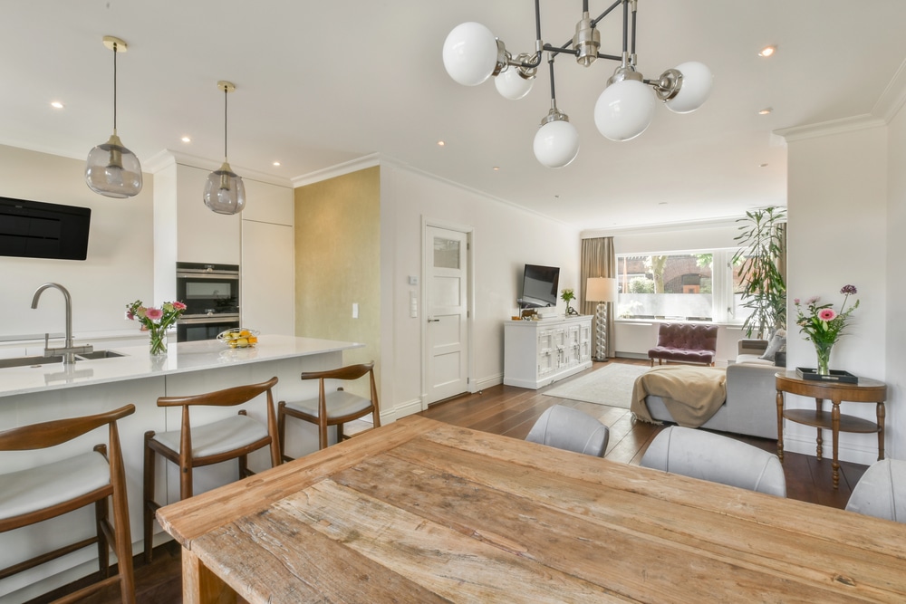 Modern open-plan interior featuring a bright white kitchen island and neutral-toned furniture.