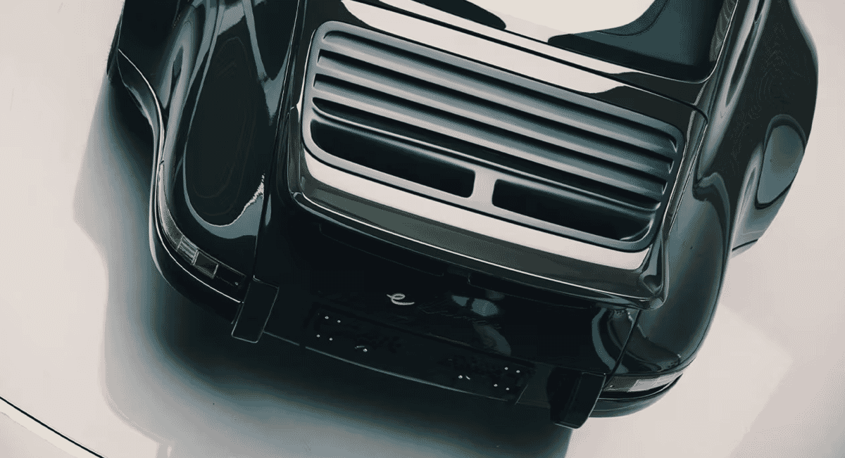 Top-down view of the rear grille and sleek black curves of a vintage Porsche.