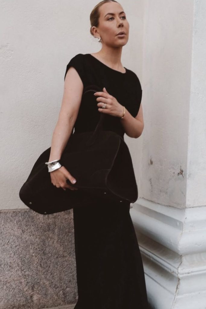 Street style shot of Alexa Dagmar wearing silver jewelry with a black outfit.