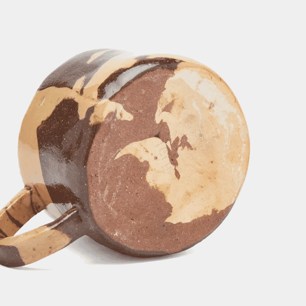 Side profile of a ceramic mug showing swirling brown and beige glaze patterns.