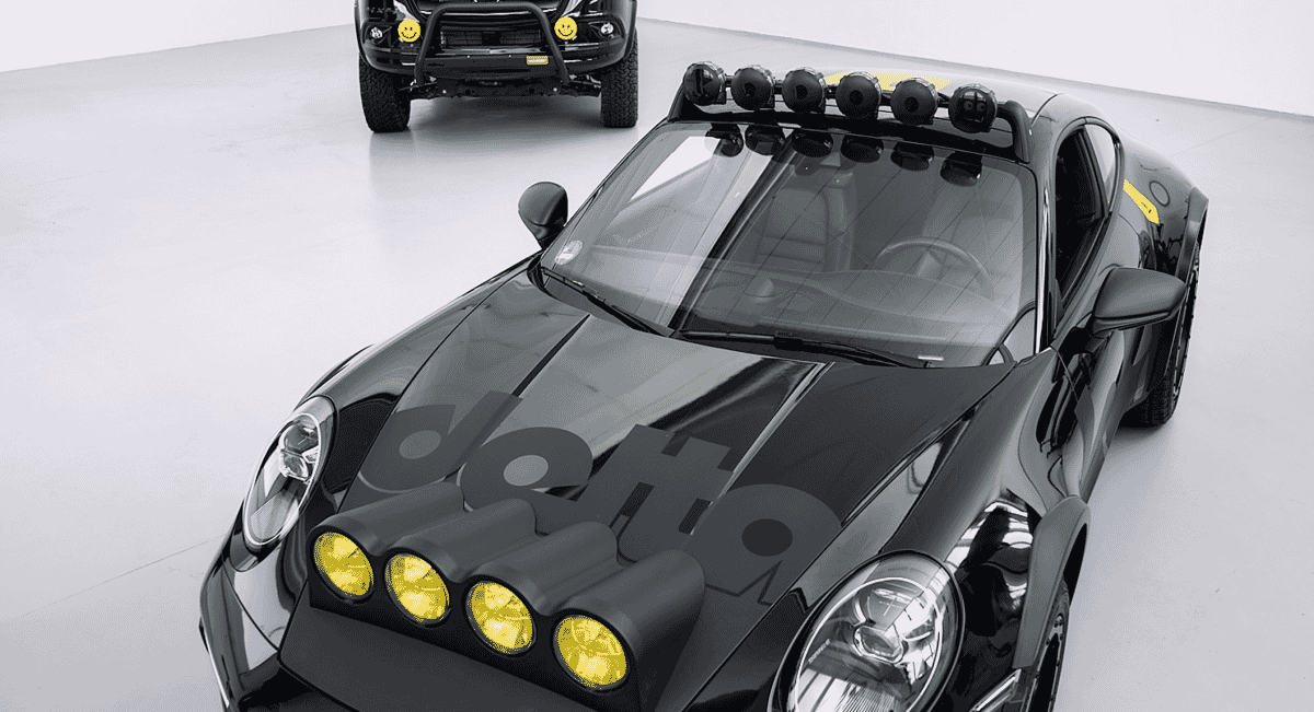 Close-up of a modified black Porsche 911 Safari with prominent yellow rally-style headlamps.