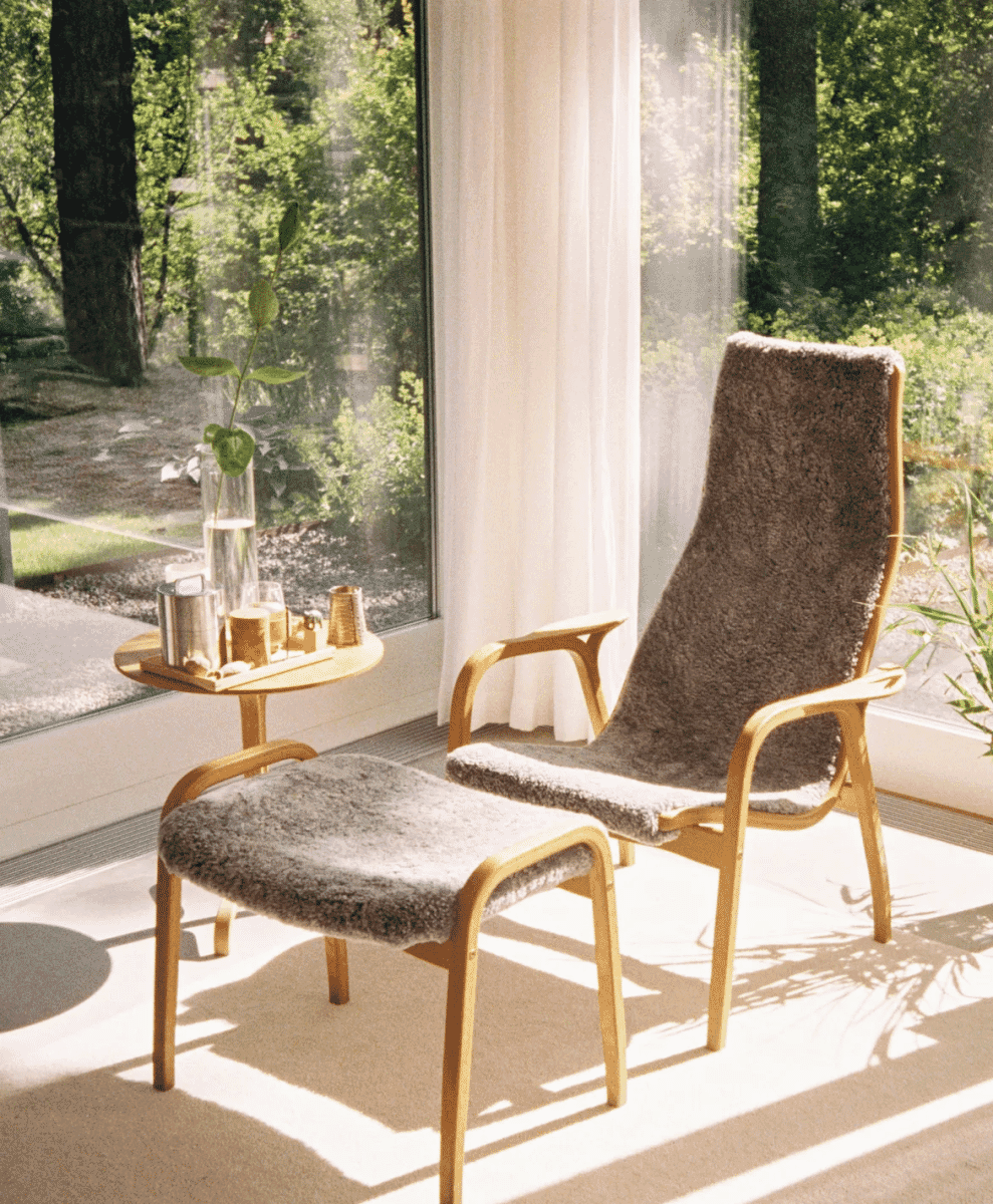 Swedese Lamino armchair with an oiled oak frame and sheepskin upholstery in a sunlit room.