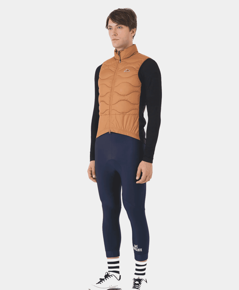 Male model wearing a brown quilted thermal gilet over a black base layer.