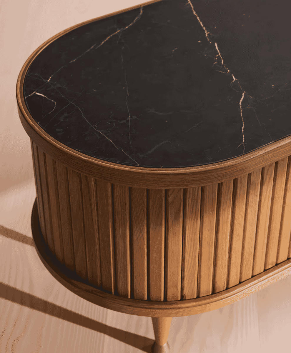 Close-up of a wooden media unit with tambour paneling and a black marble top.