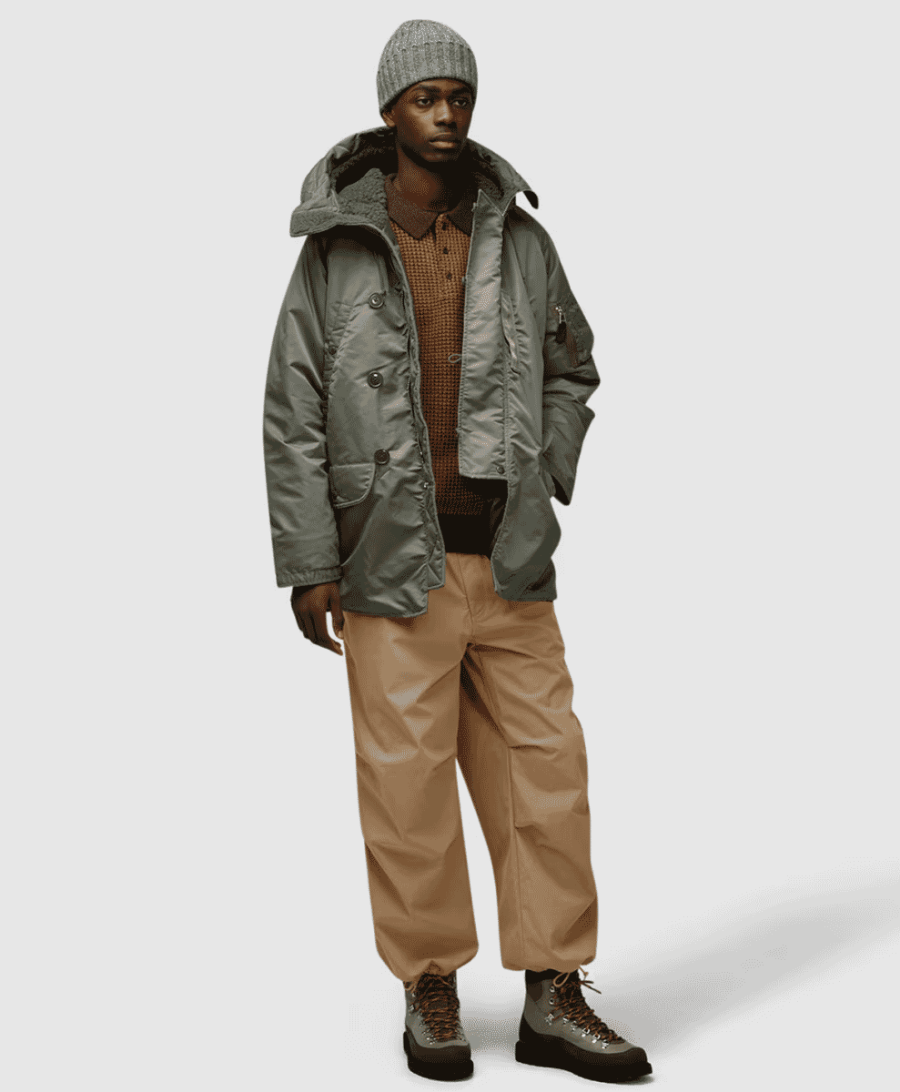 Model in a gray N-3B parka with a shearling-lined hood and beige cargo pants.