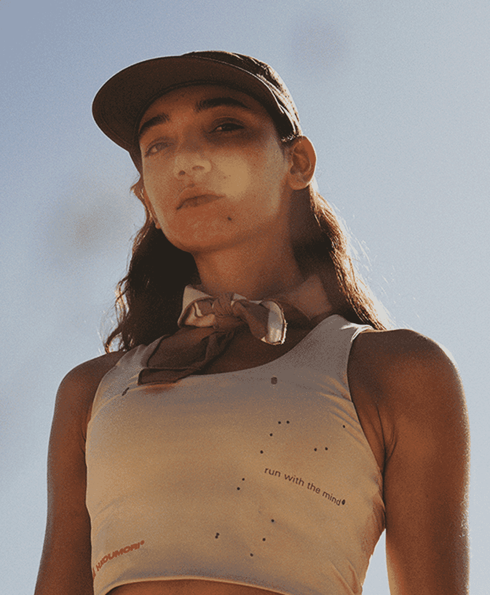Close-up of a white perforated tank top with 'run with the mind' text.
