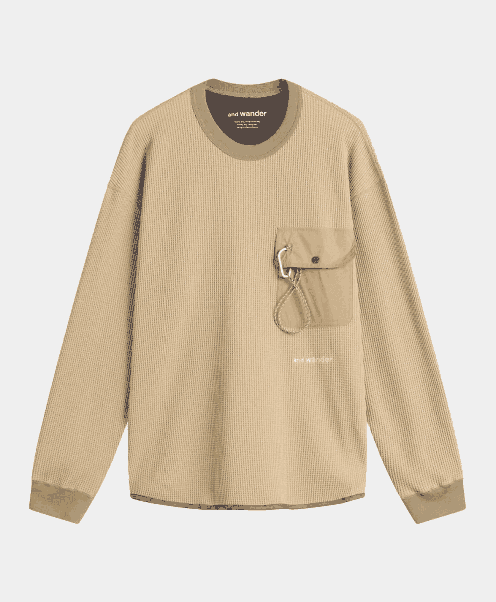 Beige long-sleeve waffle knit tee featuring a chest pocket with a technical carabiner closure.