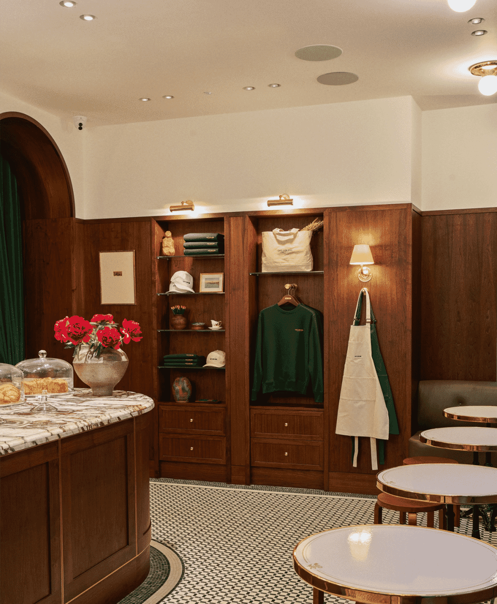 The wood-paneled interior of a boutique displaying the apparel collection and café seating.