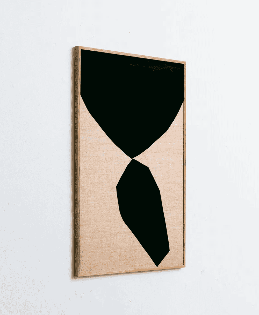 Abstract black geometric shapes on a beige textured background in a light wood frame.