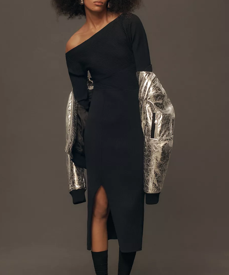 A model in an Anthropologie off-the-shoulder black sweater dress.