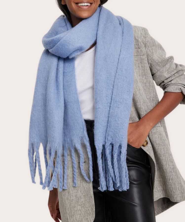 An oversized cream wool scarf with large tassel fringe.