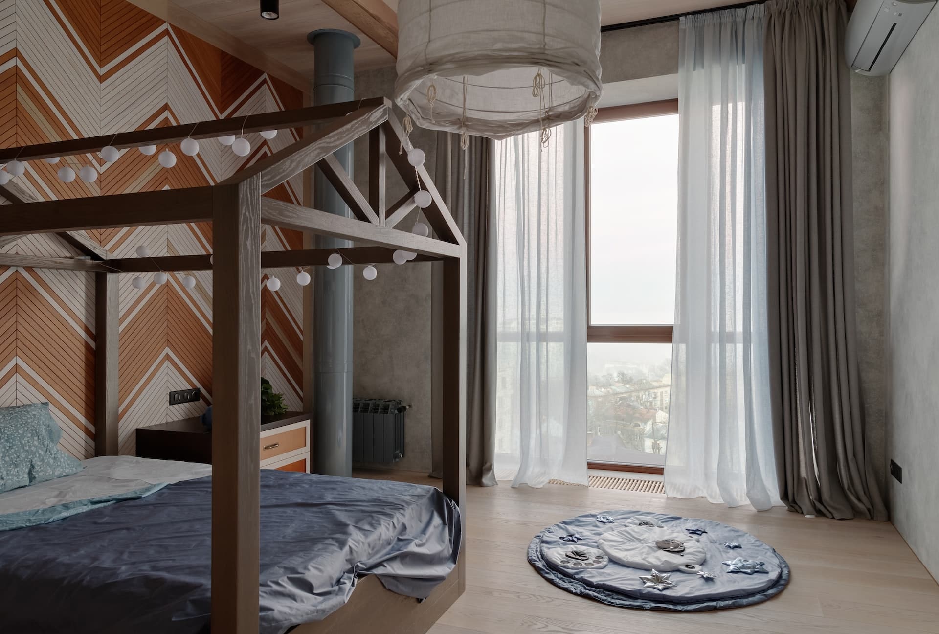 A cozy bedroom with a wooden canopy bed and layered curtains puddling onto the floor.